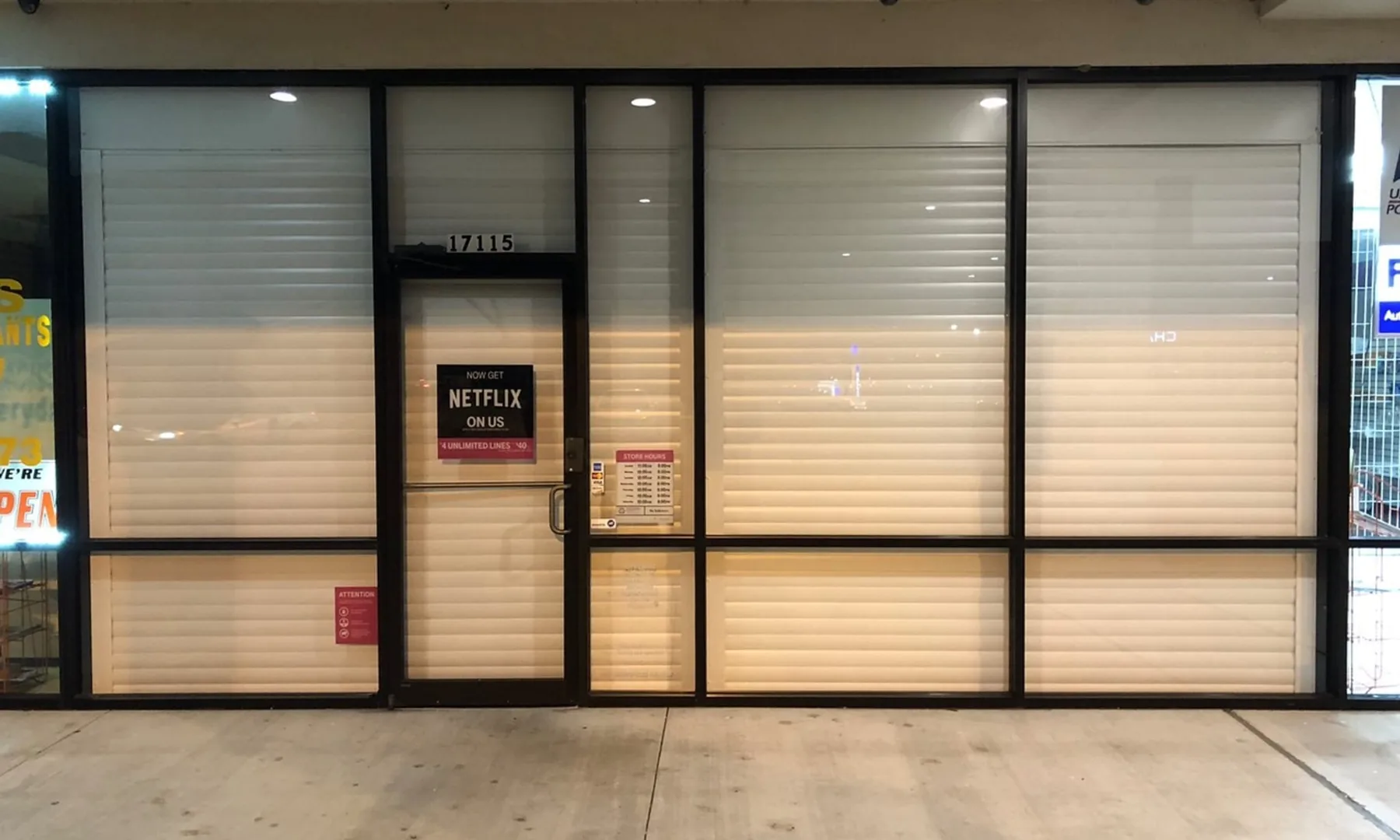 White roll-down shutters securing a commercial storefront