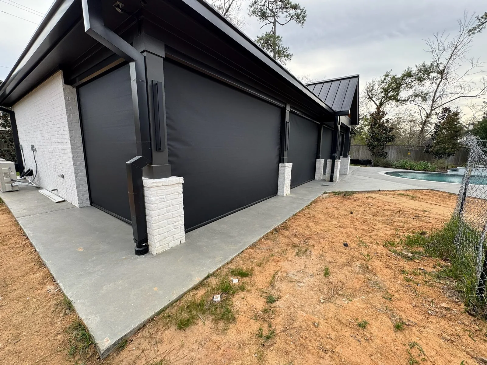 Modern home side view with dark exterior shades and pool