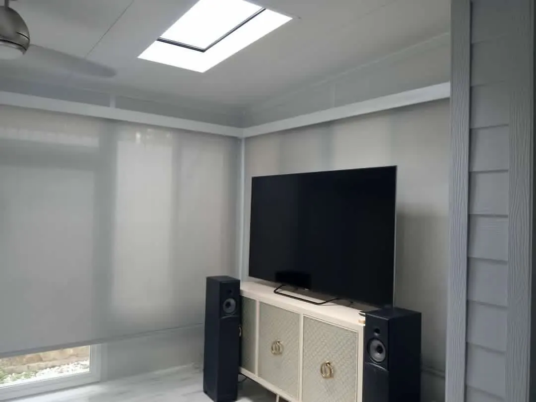 Light-filtering TMAX interior shades surrounding a television in a bright room